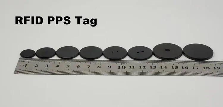 Round black RFID PPS button tags in eight diameters shown with a centimetre ruler for scale